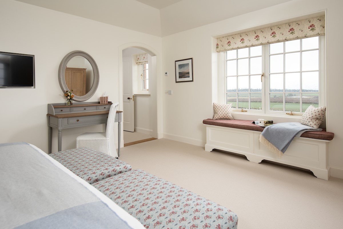 Hillside Cottage - bench seat in bedroom one and dressing table with mirror above