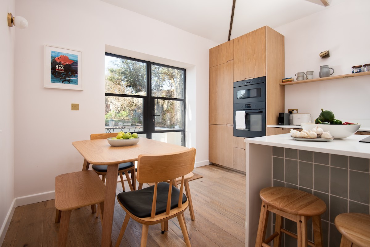 East Lodge Home Farm - bright open-plan kitchen and dining area with patio doors leading out to the garden