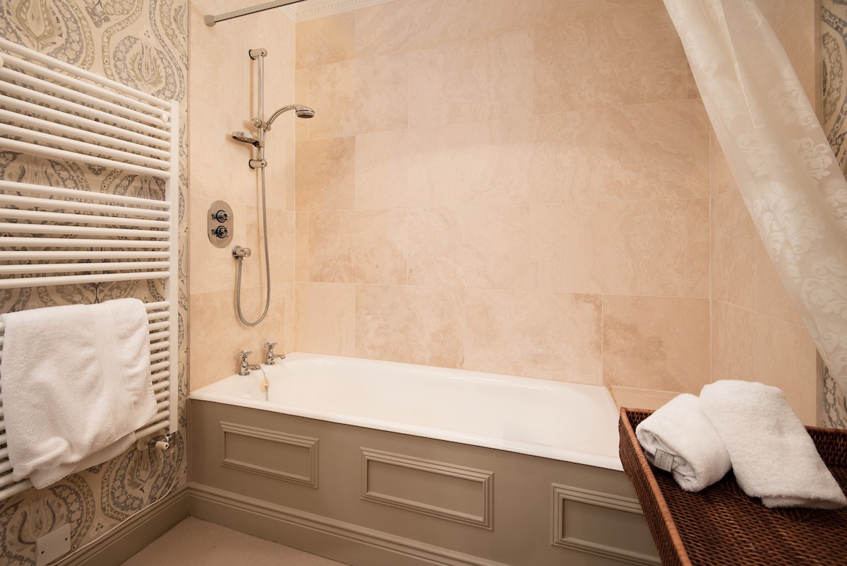 Broadgate House - bedroom four en-suite bathroom with bath and shower over, WC and basin