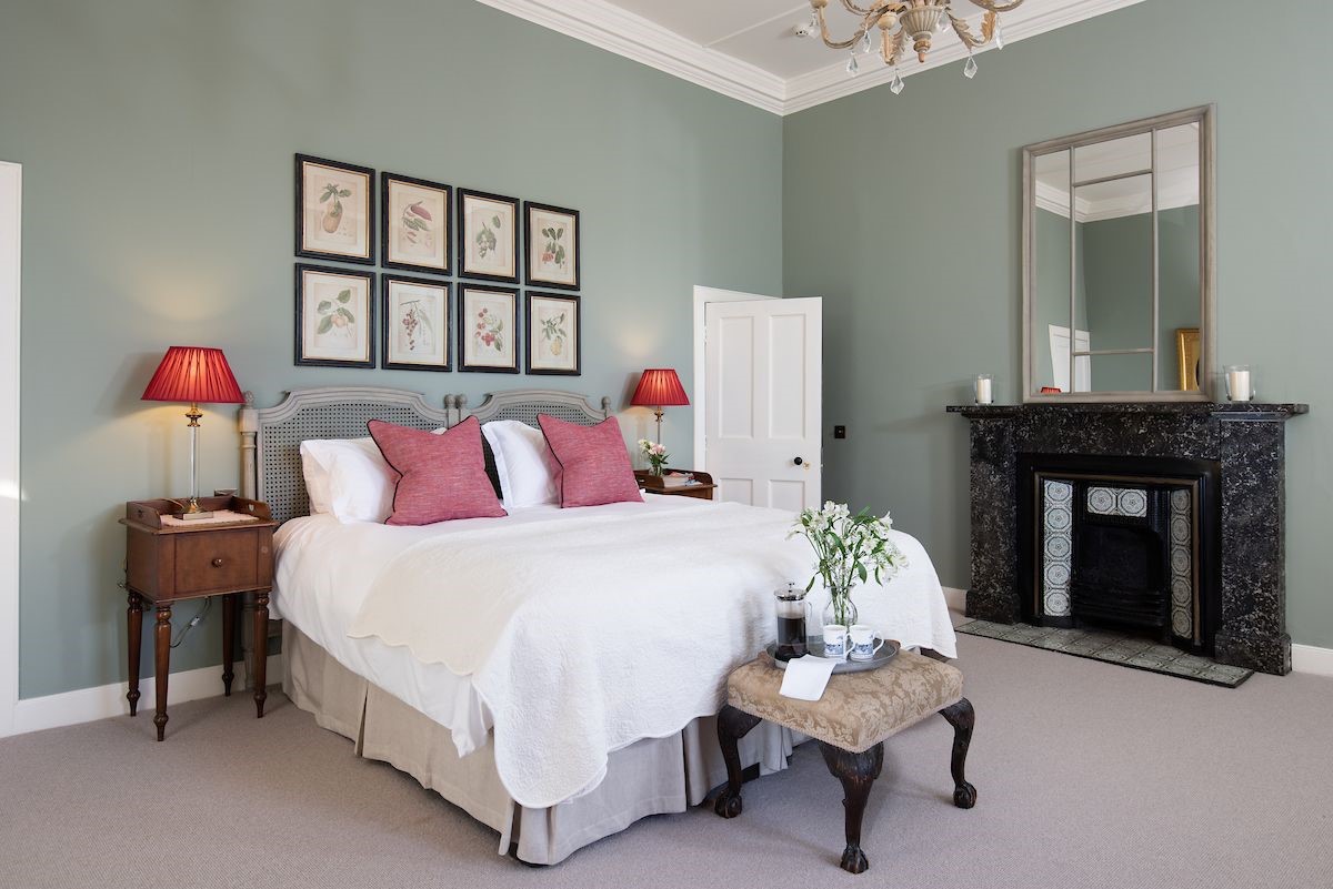 Glenburnie - bedroom with zip and link beds, decorative fireplace and side tables