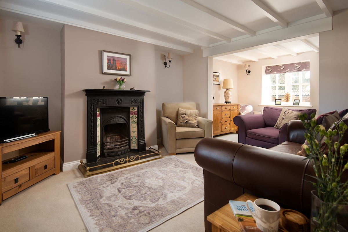 Rose Cottage, Huggate - the evening sitting room with decorative fireplace and beamed ceiling