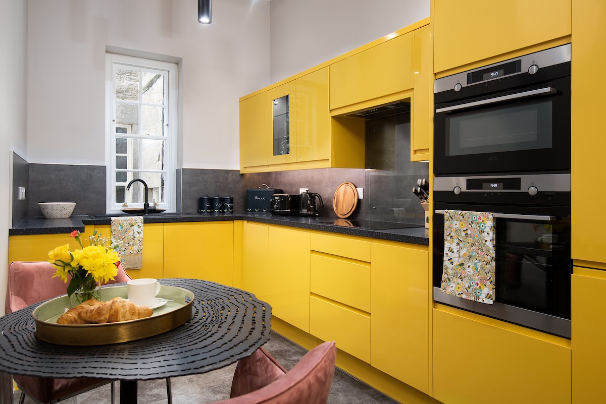 The Scott Apartment - a second kitchen in the Scott Apartment in bright Bumble Bee yellow adds a heavenly pop of colour