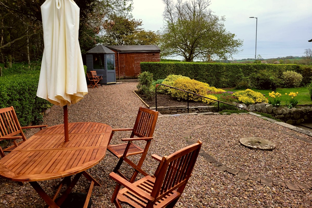 Bughtrig Cottage - the outside seating area with views over the pretty garden