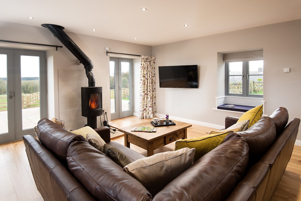The Granary at Rothley East Shield - living room with wood burner and views of surrounding countryside