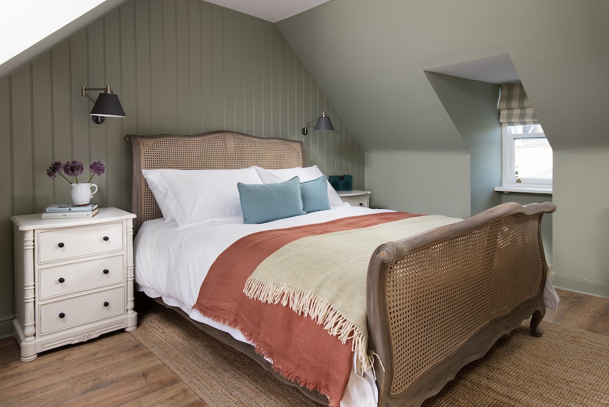 Campsie Cottage - the dual-aspect master bedroom is on the first floor, with a French-inspired bed set beneath sloping eaves