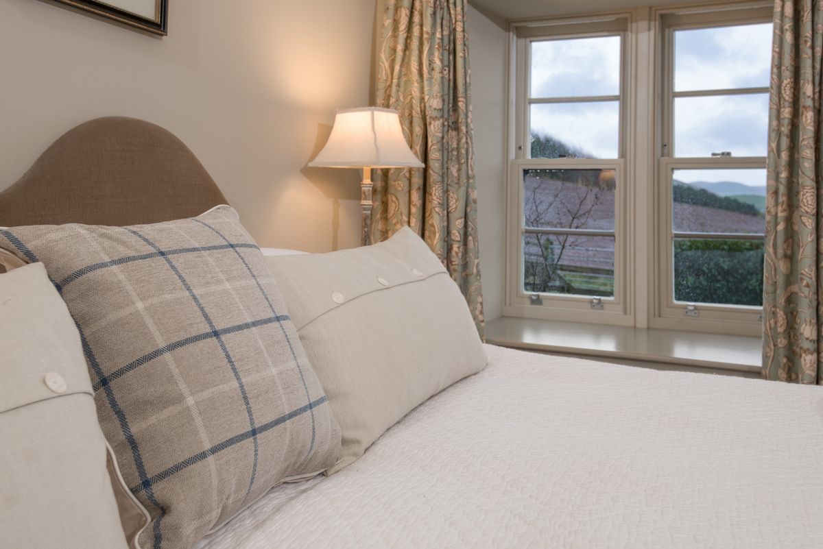 Barley Hill Cottage - bedroom one with neutral furnishings and view of the Cheviots