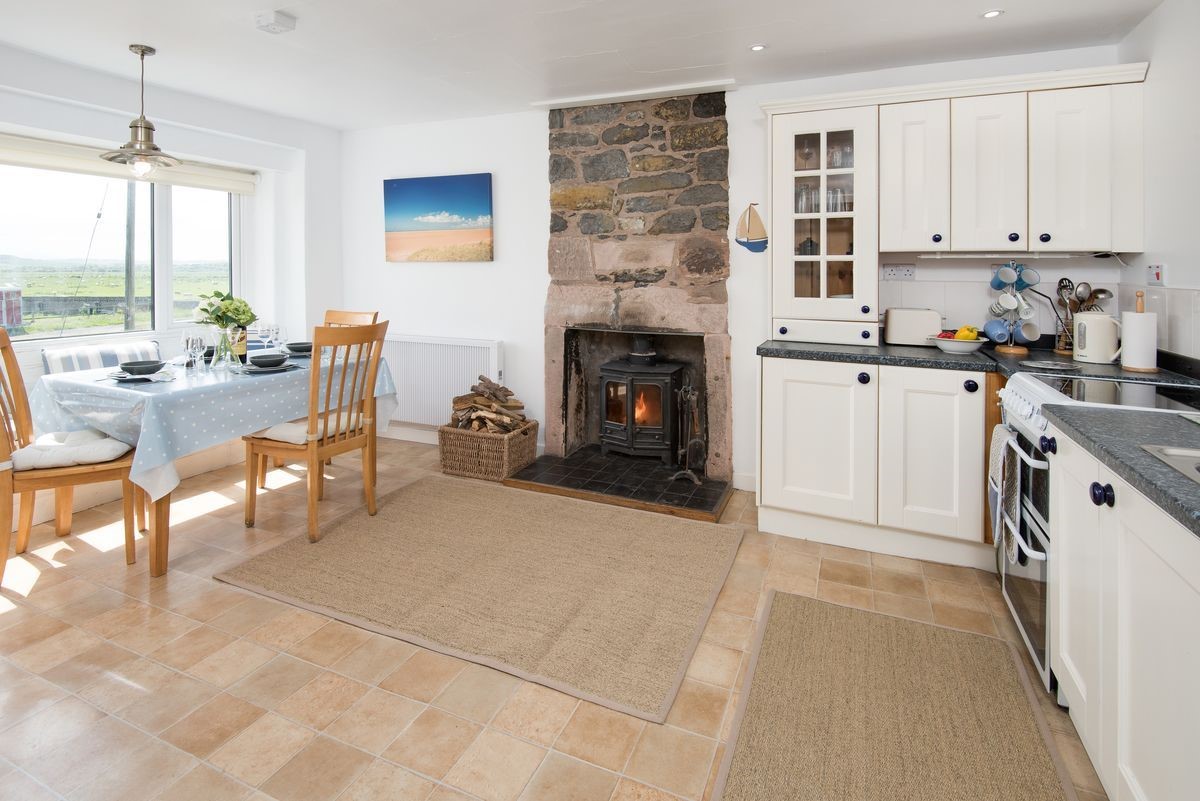 Beachcomber Cottage - kitchen with dining table and wood burning stove