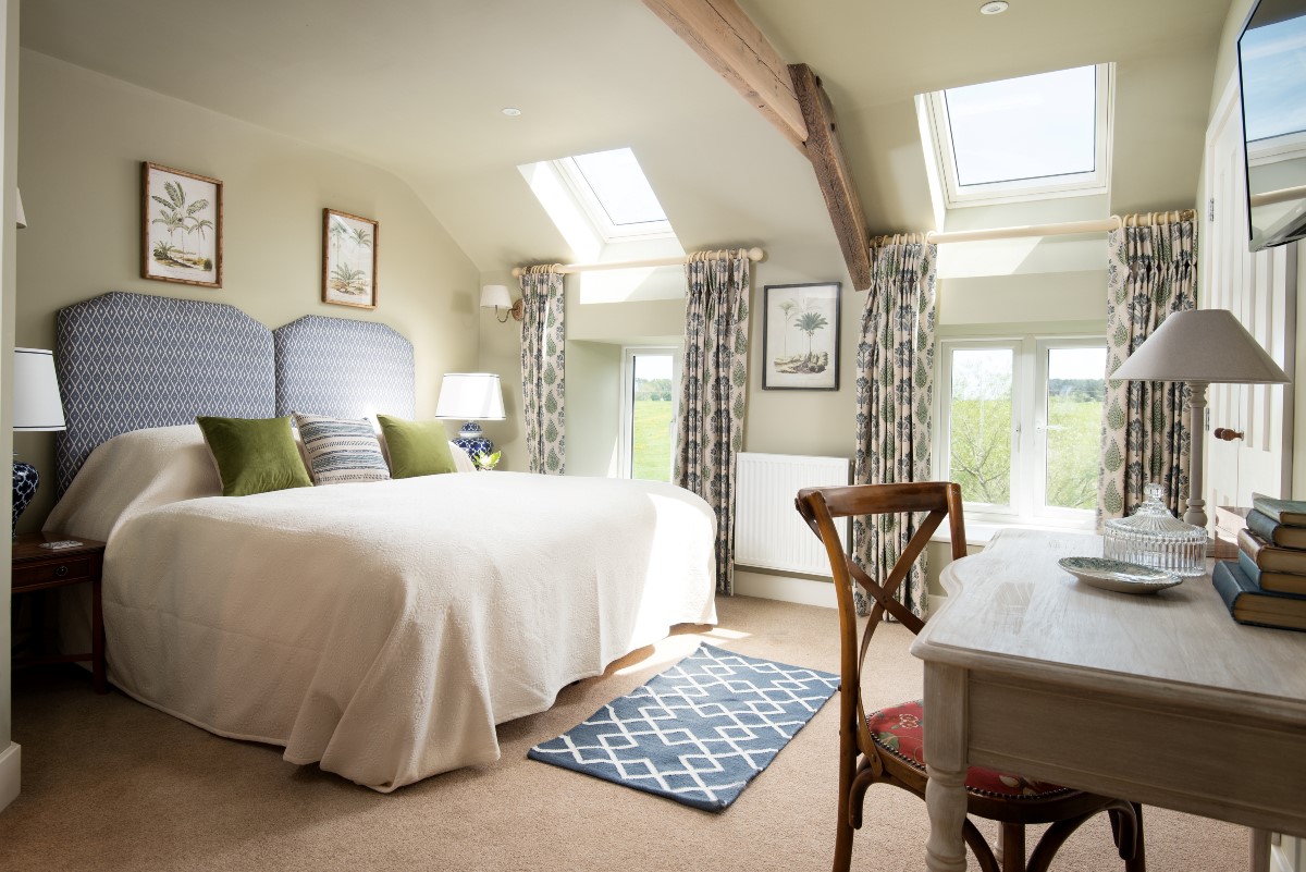 Brunton Granary - bedroom two with super king size bed, dressing table and Velux windows offering super views of the surrounding countryside