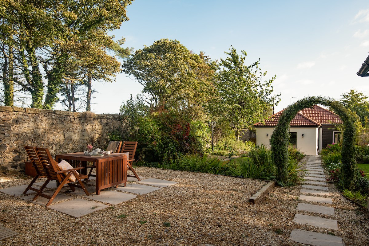 East Lodge Home Farm - gravelled area in the garden with outdoor dining table and chairs