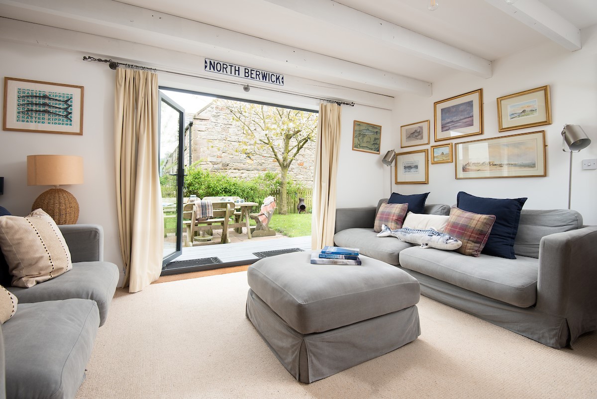 Nook - bright and spacious sitting room with comfortable seating and large bi-fold doors opening out onto the garden