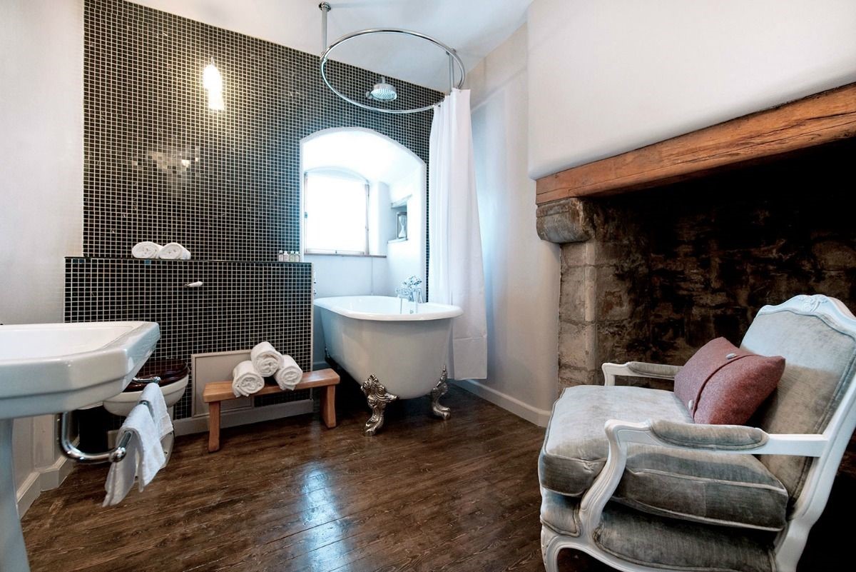 Aikwood Tower - Buccleuch bathroom with original fireplace and bath with shower over
