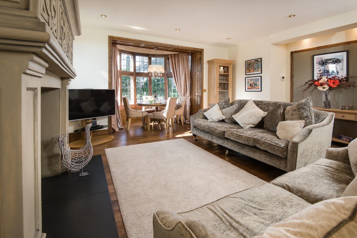 Captain's Rest - the sitting room with two large sofas, dining area, Smart TV and large fireplace
