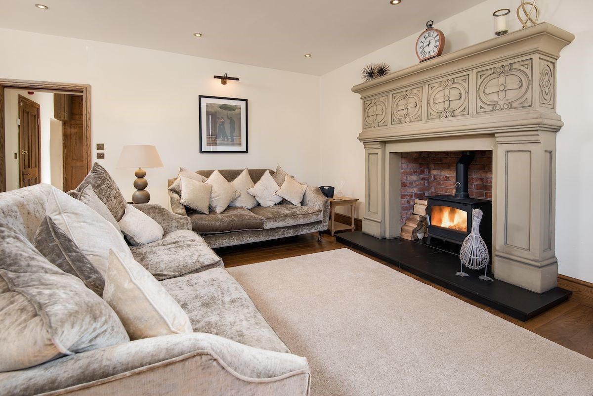 Captain's Rest - two large sofas are set around the large statement fireplace and wood burning stove