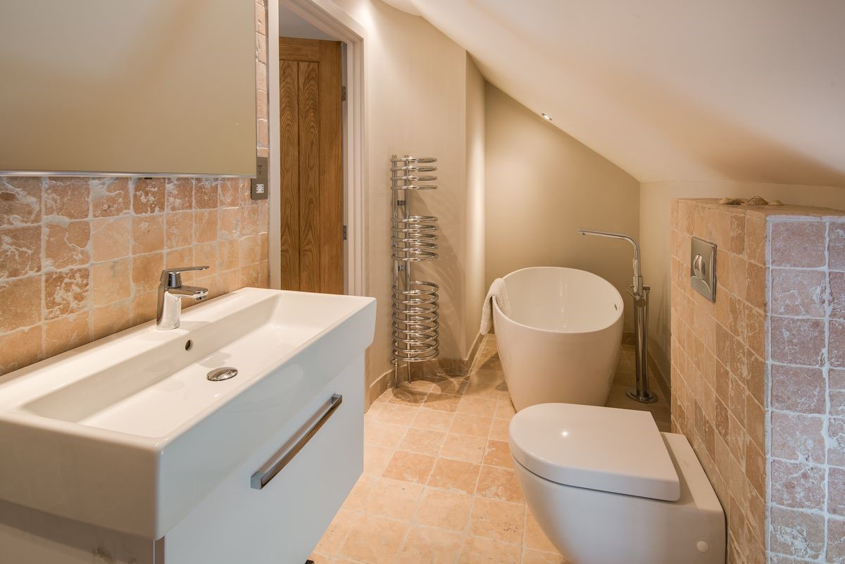 Coach House - bedroom three en suite bathroom on the first floor with free-standing bath, WC and basin