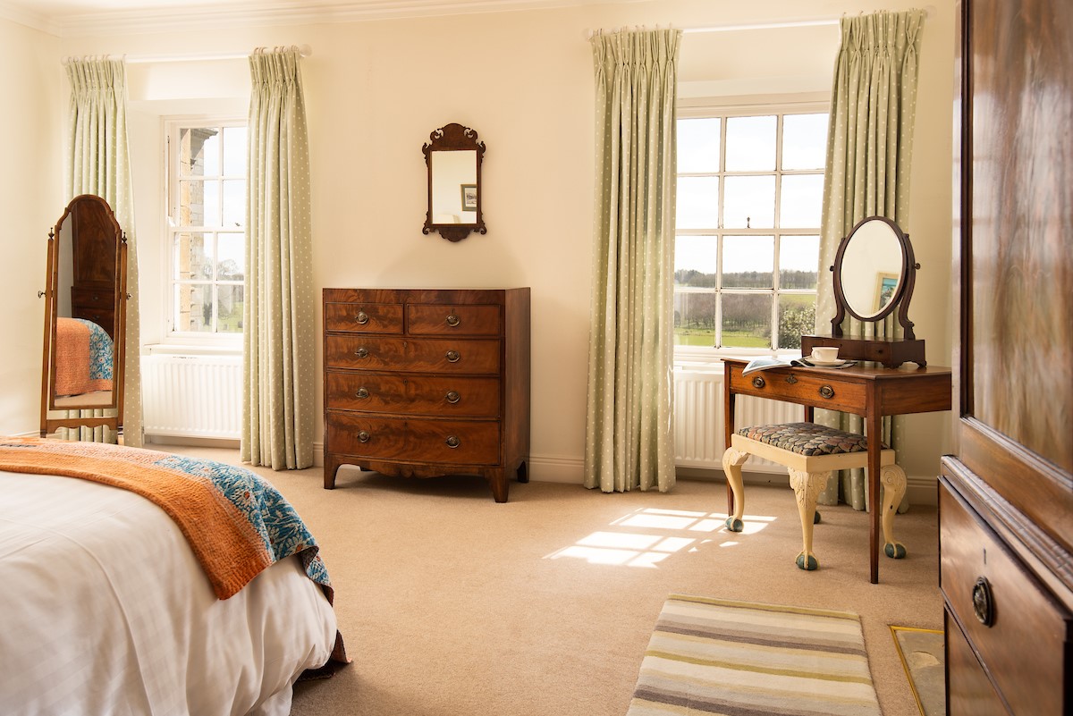 The West Wing, Capheaton - antique furniture frames the sash windows in the bedroom