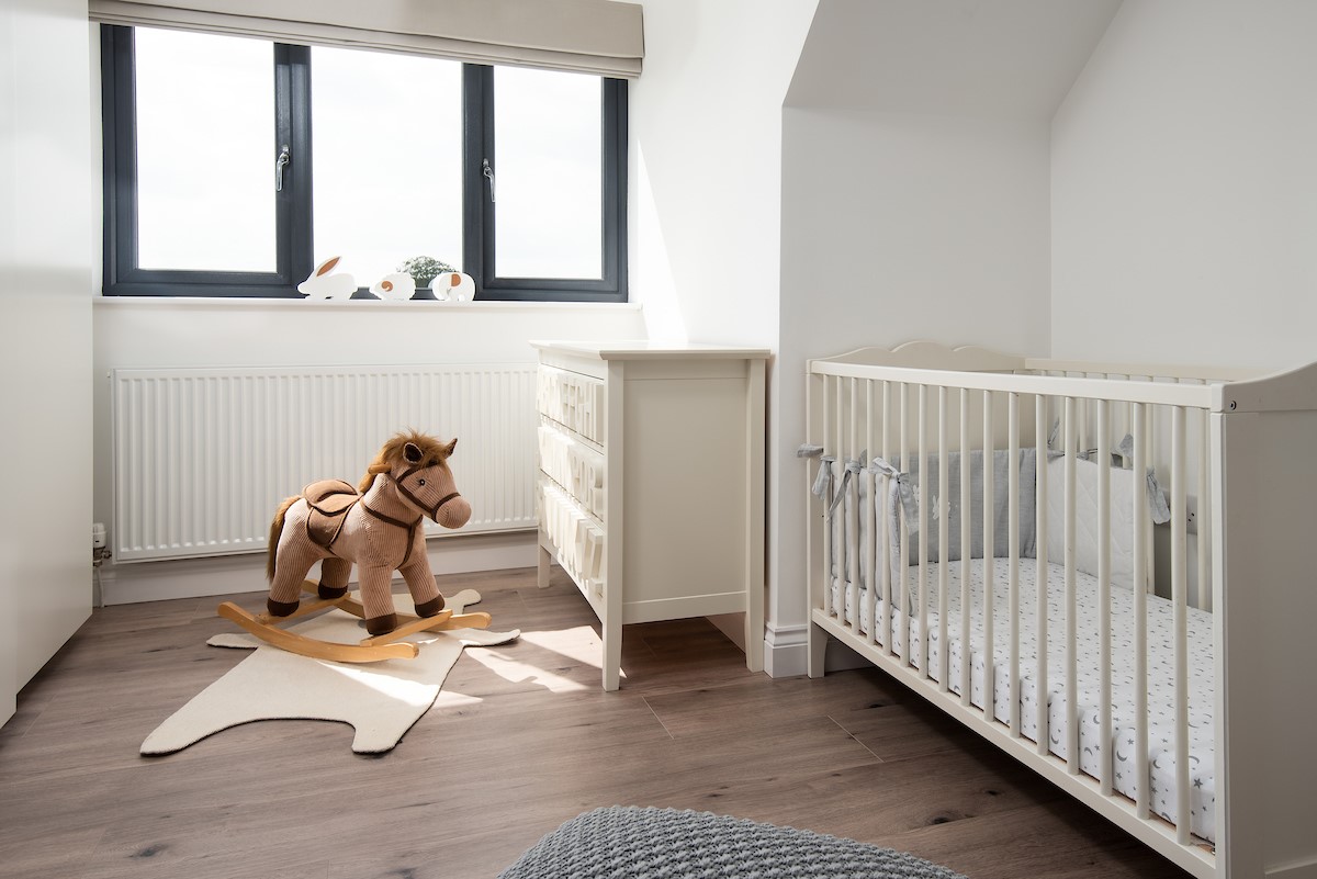 Sunwick Cottage - full size cot in bedroom three with a charming rocking horse for toddlers