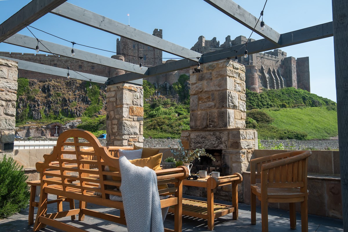Castle View, Bamburgh - spacious patio with outdoor fireplace and views of Bamburgh Castle