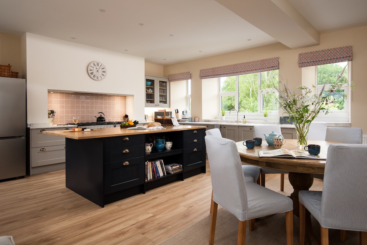 Wark Farmhouse - the spacious kitchen with large island and dining table seating up to eight guests