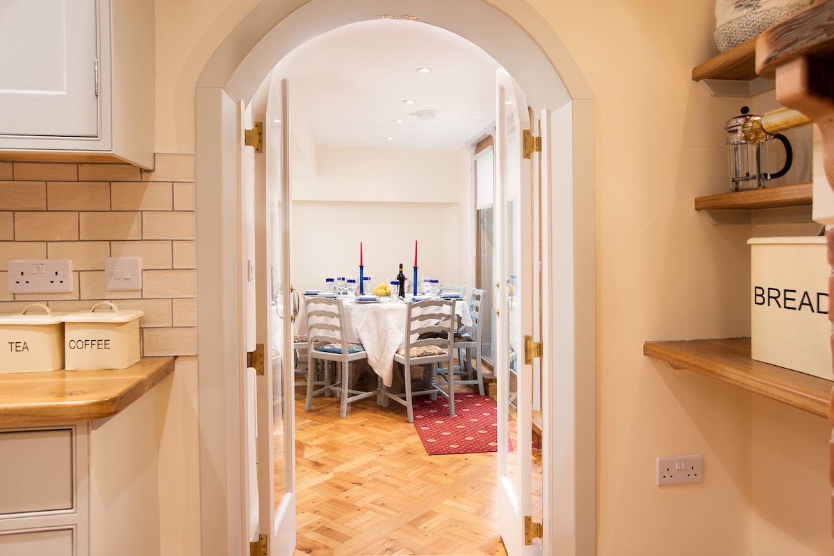 The Craftsman's Cottage - entrance from the dining area to the kitchen through the pretty arched doorway