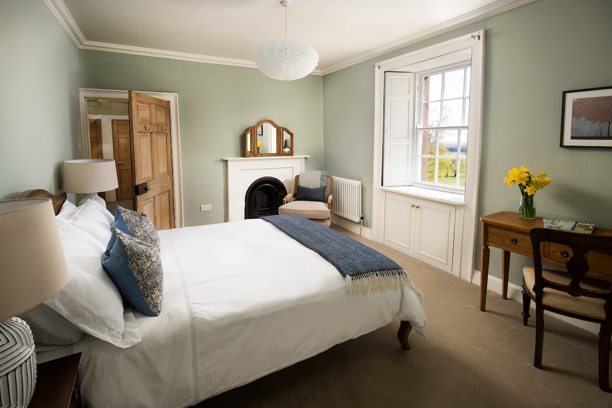 Cairnbank House - bedroom two with decorative fireplace and dressing table enjoys front facing views