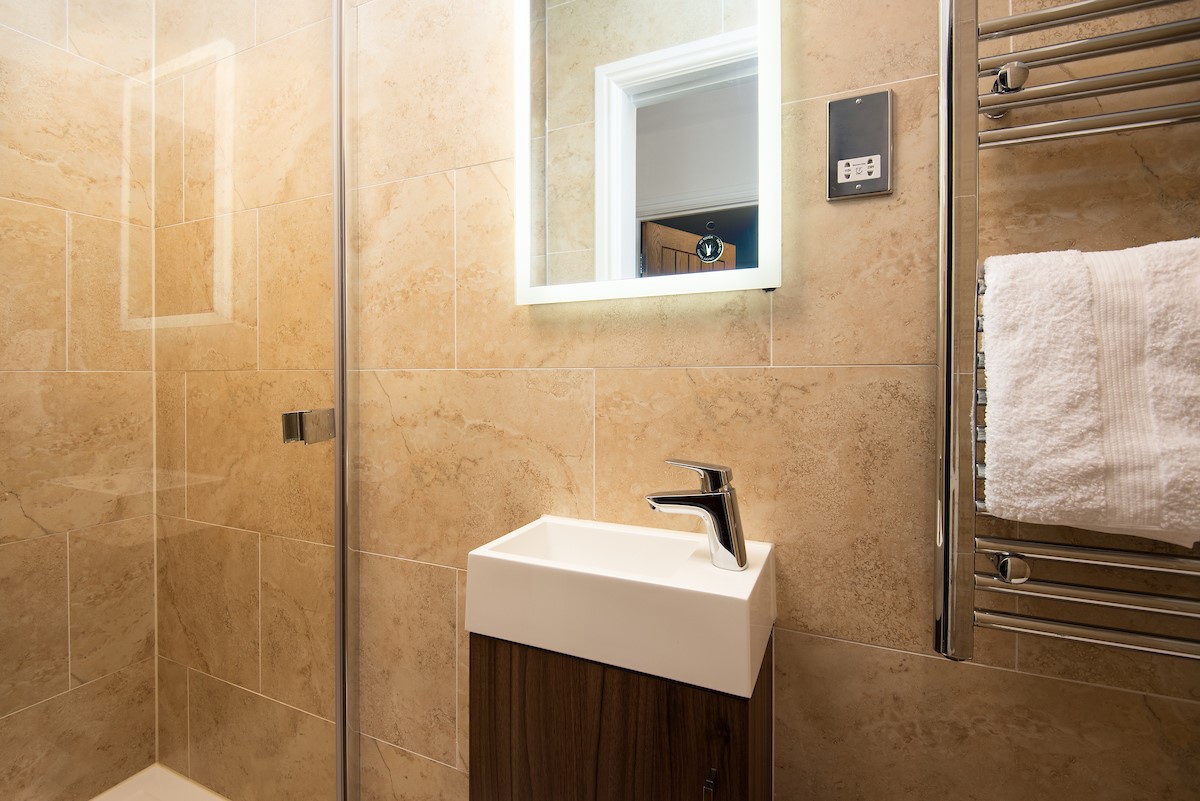 No. 6 - family shower room with walk-in shower, heated towel rail, WC and basin with illuminated mirror above