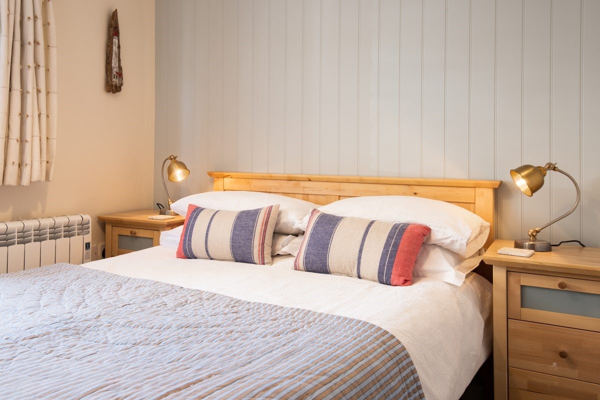 Farne View - bedroom one with double bed and pastel blue feature wall panelling