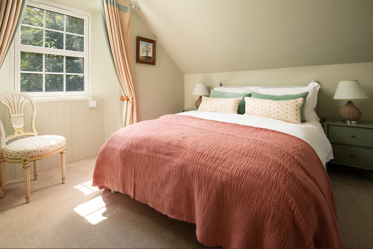 Wood Cottage - bedroom one with 4'6" double bed, bedside tables, occasional chair and built-in wardrobe