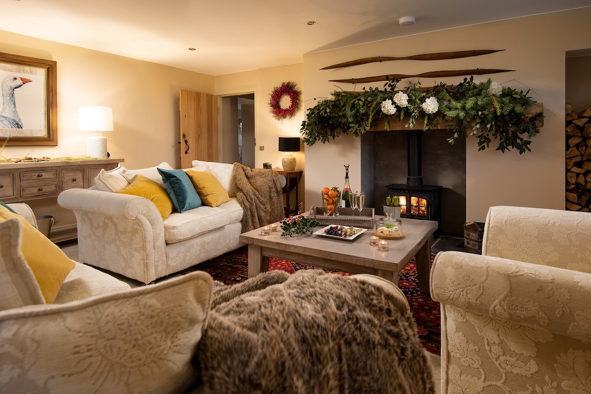 Goose Cottage at Christmas - sitting room with a large fresh foliage garland, mounted upon the timber mantel