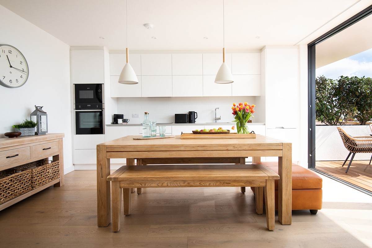 6 The Bay, Coldingham - the sea view kitchen and dining area combines a streamlined high-gloss kitchen with a chunky timber dining table and benches
