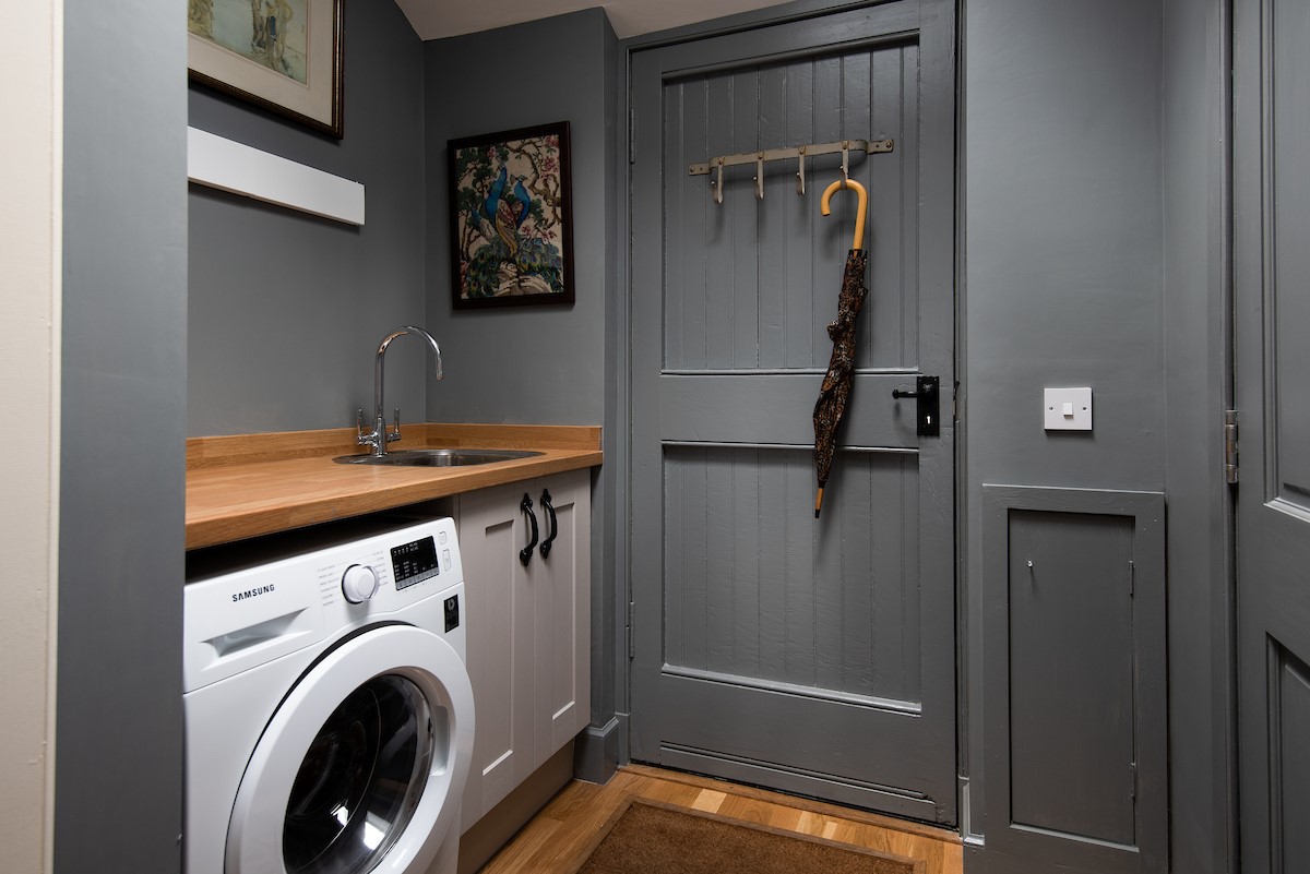 Rowchester West Lodge - utility room with washing machine and hooks for hanging outdoor kit