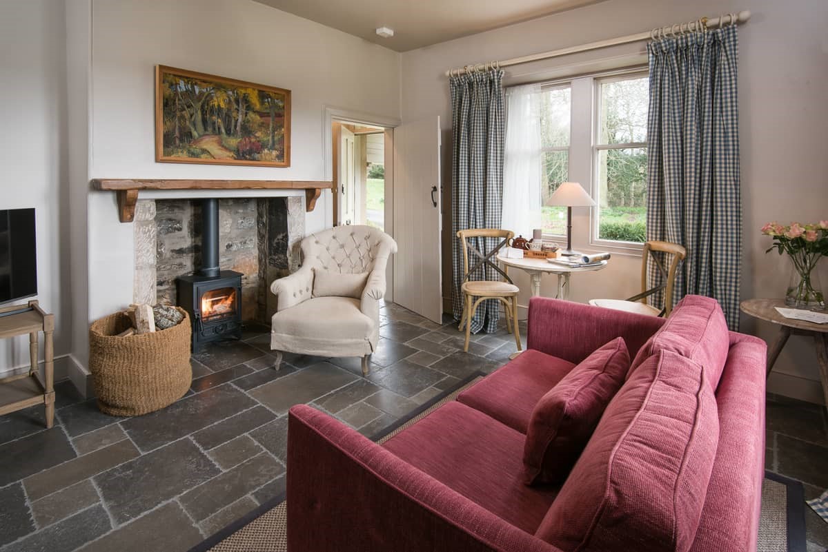 Park End - sitting room and dining space with wood burner, armchair and sofa for two