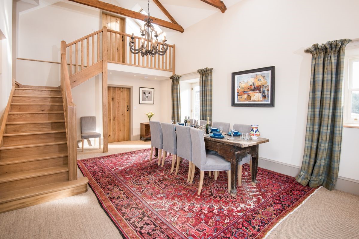 Crookhouse Mill - open-plan living area with dining table seating eight guests and staircase leading to the first floor