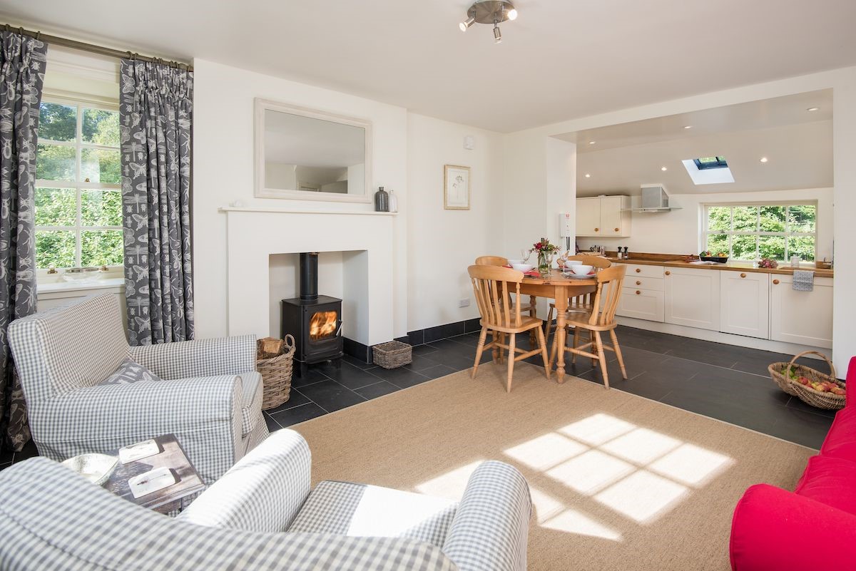 Garden Cottage - open-plan living area and kitchen with wood burning stove and dining space for four guests