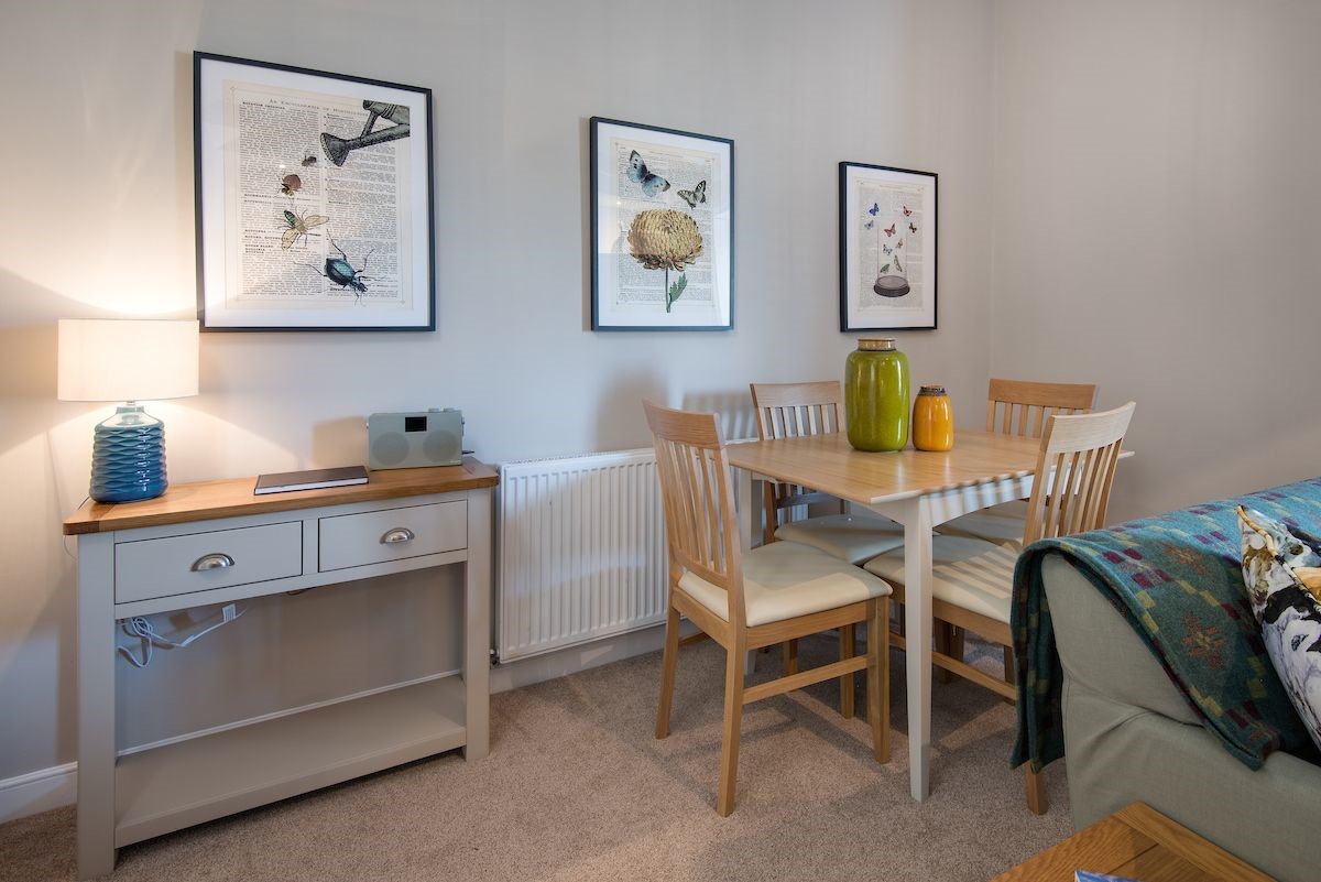 Curlew Cottage - the dining table seating four guests and botanical themed prints