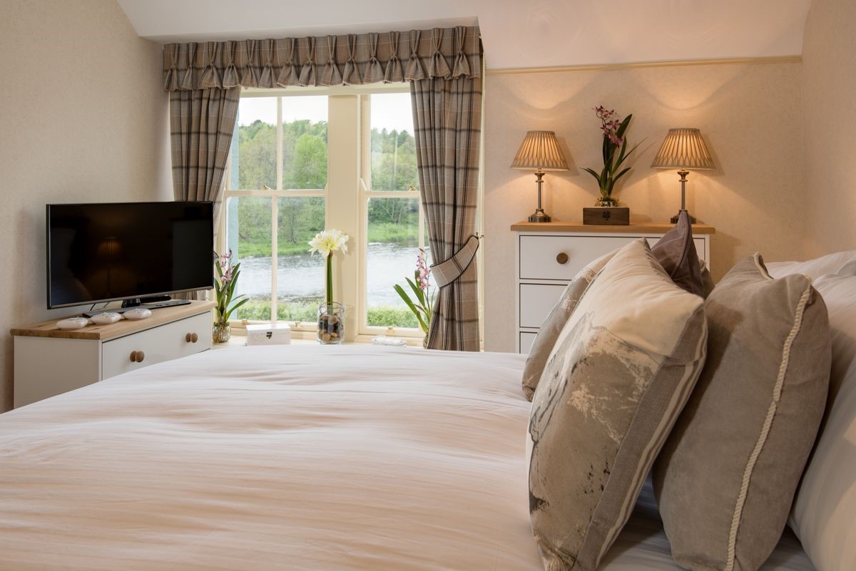 Dryburgh Stirling One - bedroom two with king size bed, chest of drawers, TV and views of the River Tweed