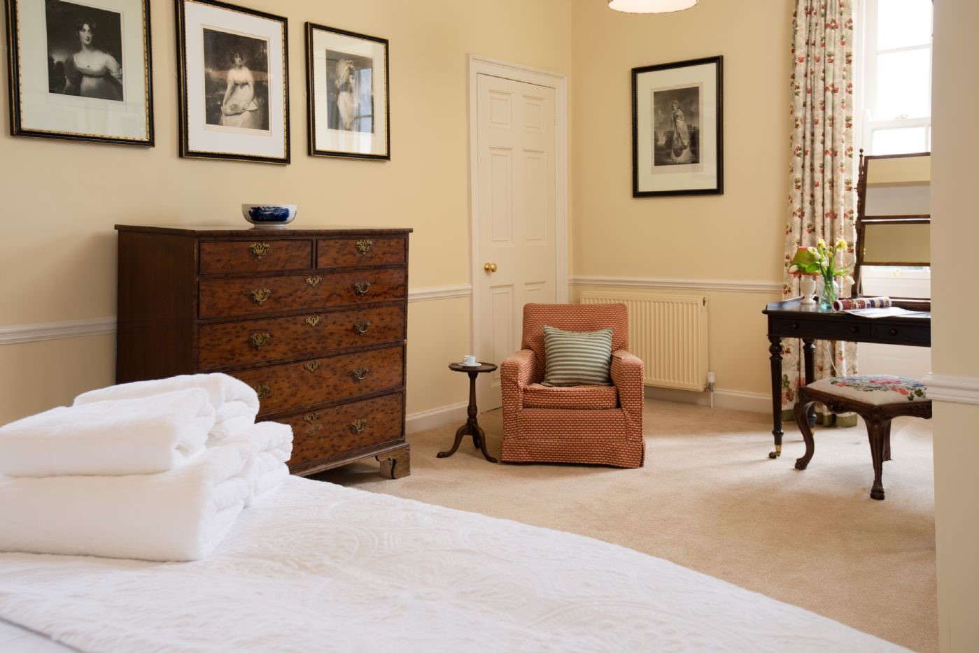 East House - bedroom one with chest of drawers, armchair and dressing table