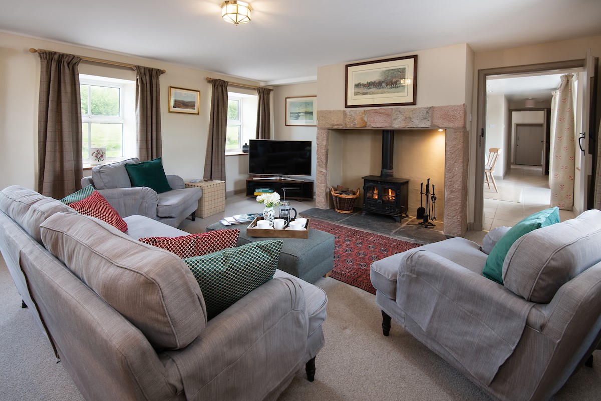 Dipper Cottage - sitting room with inglenook fireplace, wood burning stove, TV, sofa and armchairs