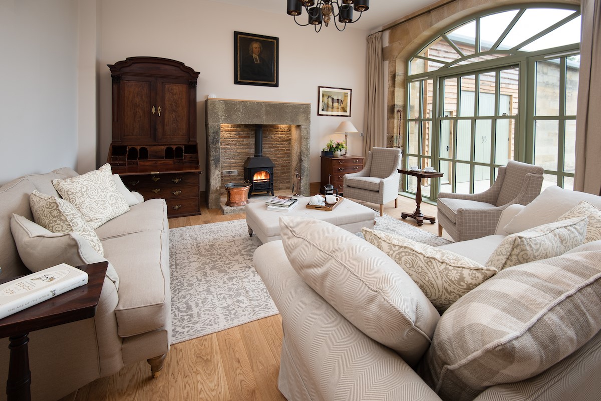 Beeswing - sitting room with inglenook fireplace with wood burning stove and large arched window
