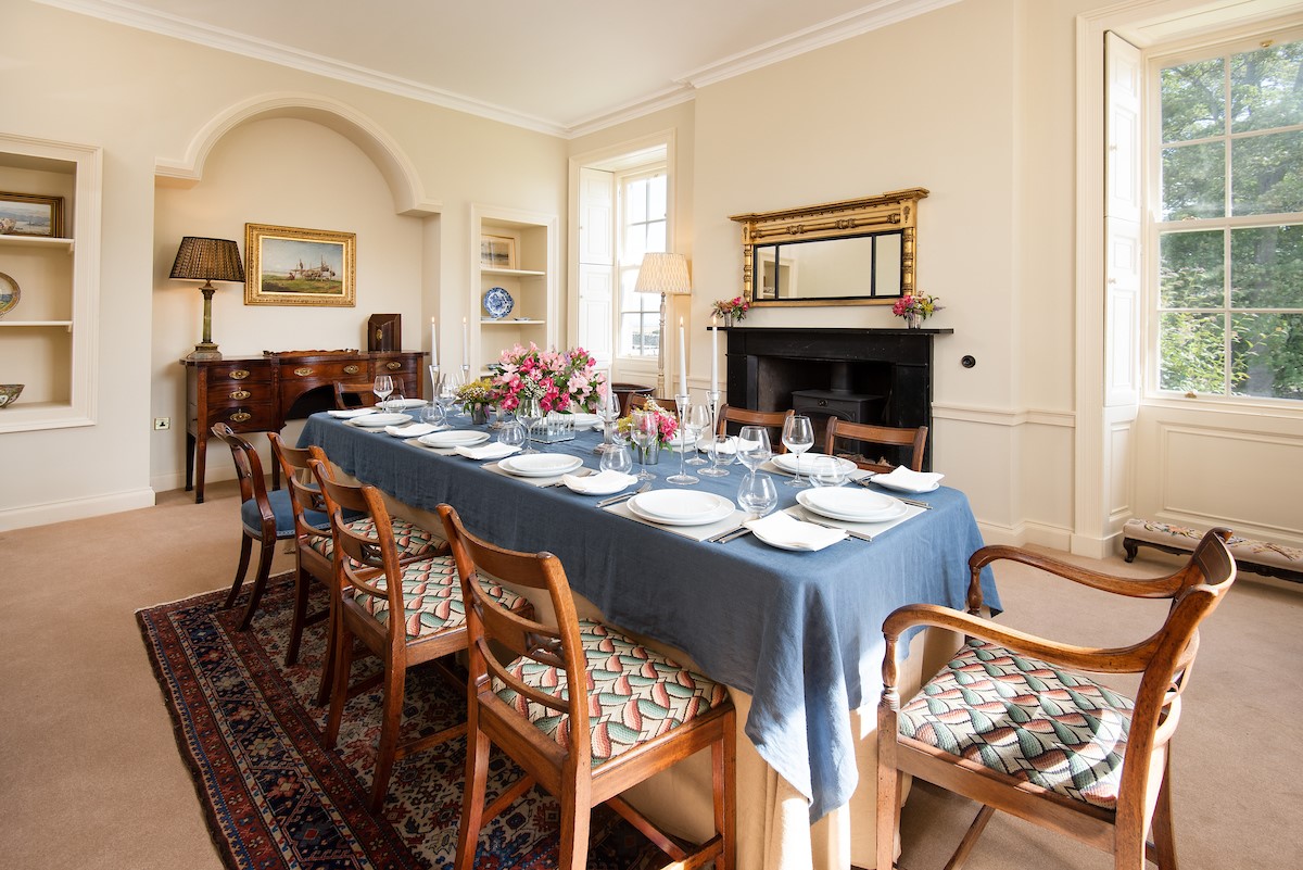 East House - dining room with seating for ten guests and wood burning stove