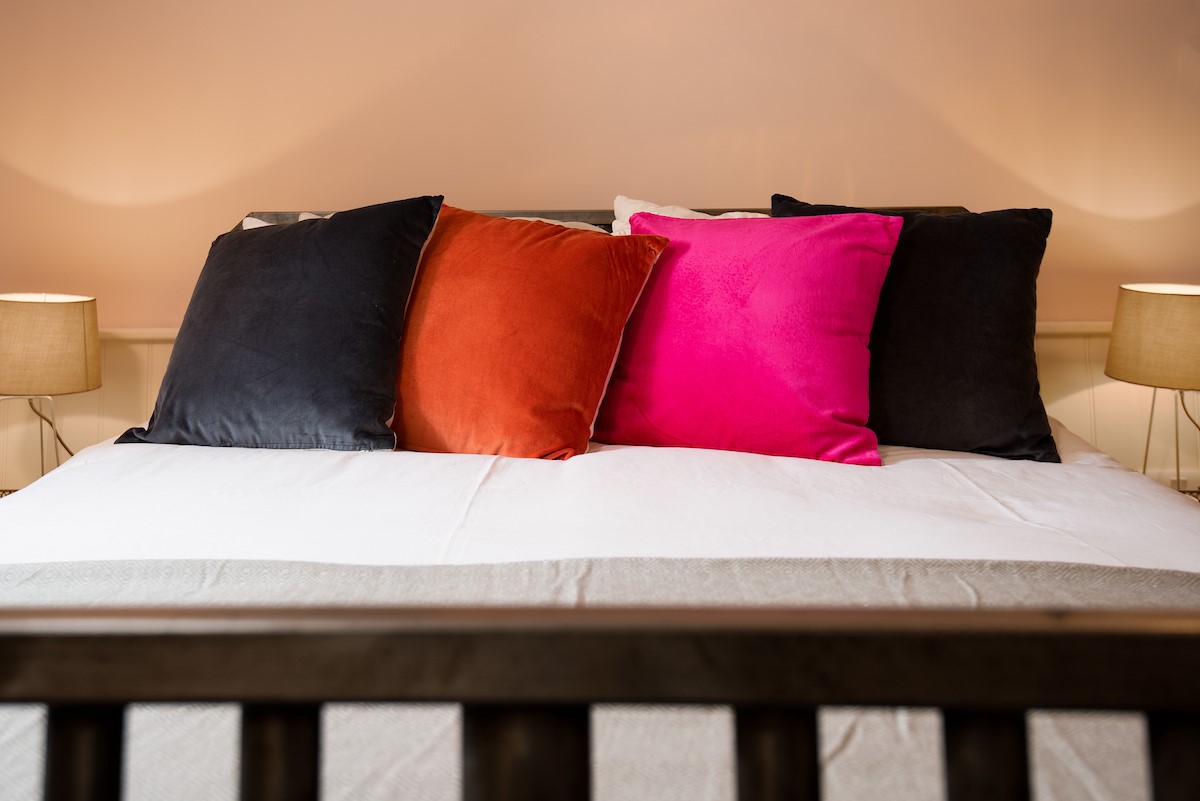 Calder Cottage - coloured cushions on the king size bed