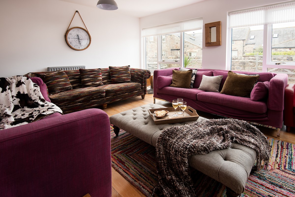 Moo House - sitting room with large comfy sofas and armchairs where you can put your feet up after a busy day