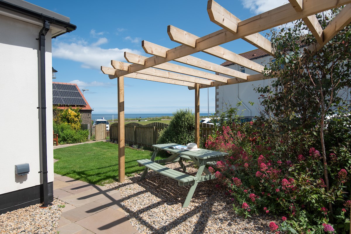 The Tumblers - outdoor dinning area with pergola in the enclosed garden