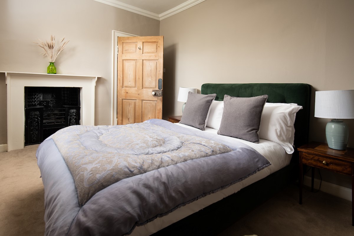 Cairnbank House - bedroom three with double bed and decorative fireplace