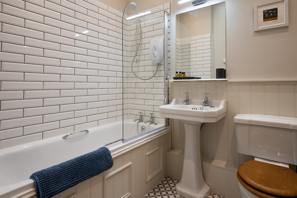 Cambridge House Cottage Number Two - bedroom one en suite bathroom with bath and shower over, WC and basin