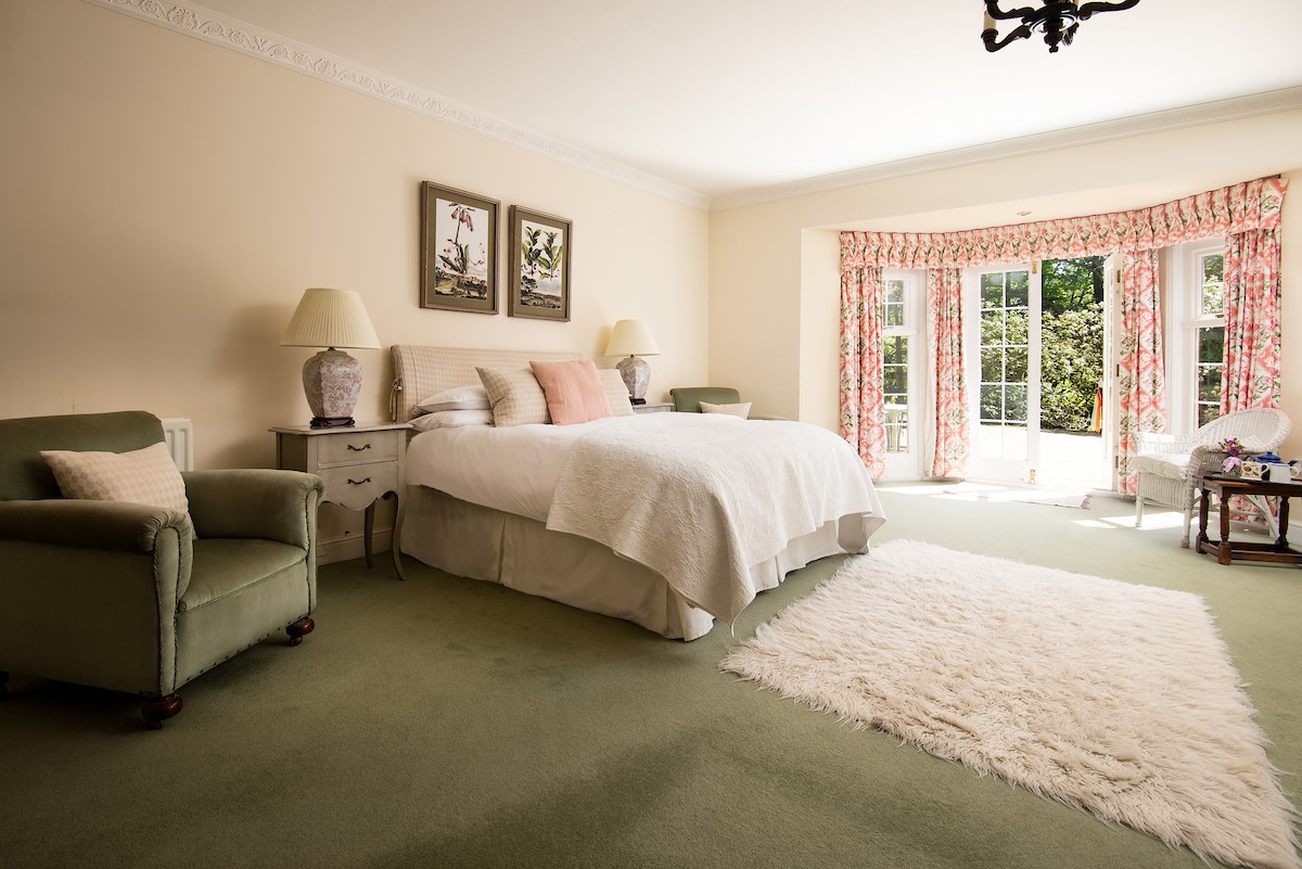 Eslington Lodge - bedroom one with double bed and French doors to garden