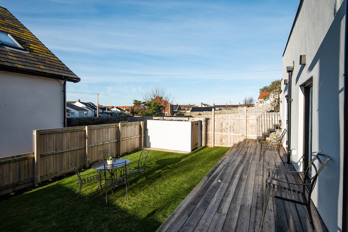 Seaside House - decking with three steps down to the lawned garden at the rear of the property