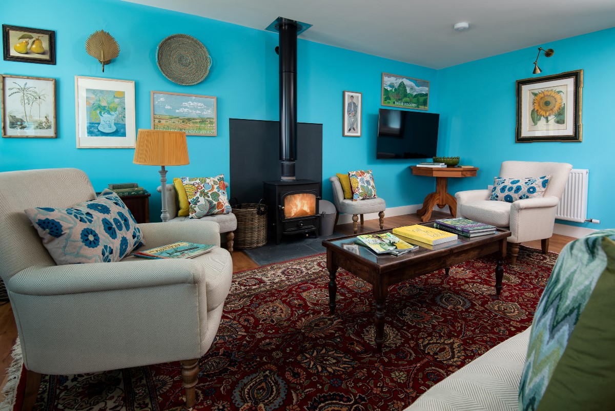 Brunton Granary - bright and colourful sitting room with cosy wood burner