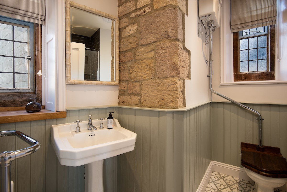 The Clock Tower at Bamburgh castle - bathroom with basin and exposed castle wall