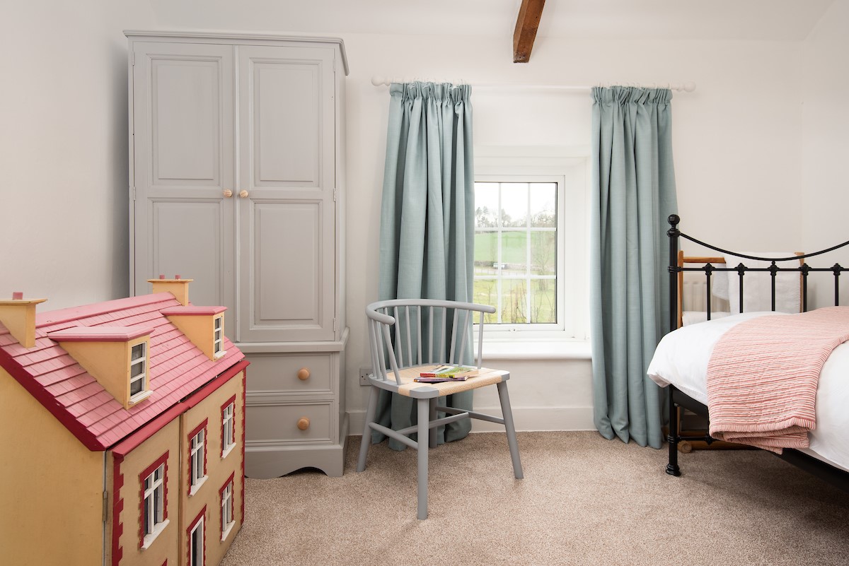 Appletree Cottage - a sweet child's bedroom with wrought iron bed and dolls house for play time