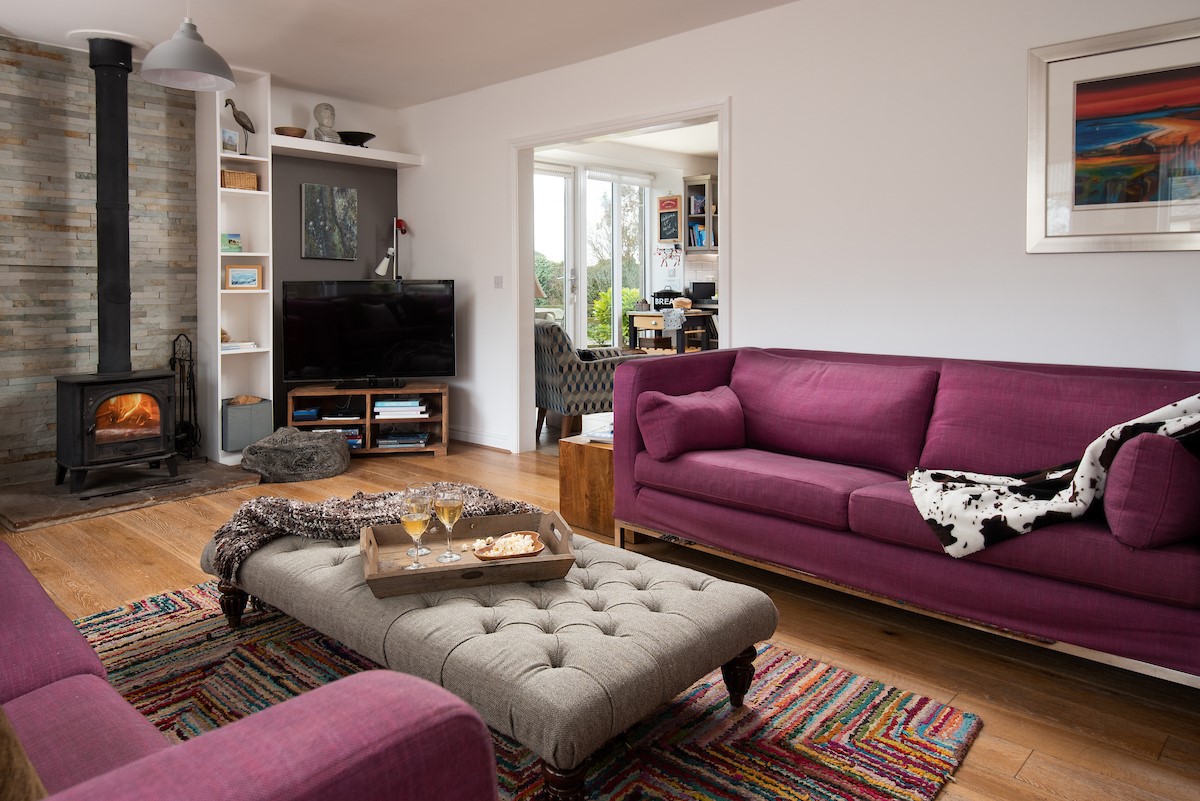 Moo House - cosy sitting room with log burner, sofas, arm chairs and Smart TV